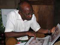 Mzee looking at Hussein's portfolio. (Category:  Travel)