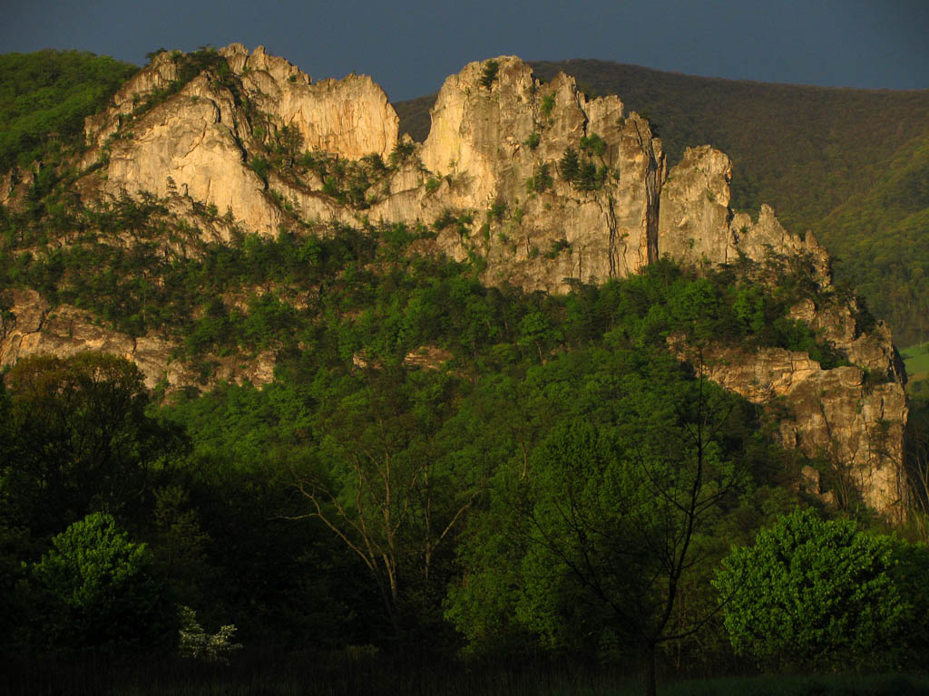 Seneca illuminated by the setting sun and topped with storm clouds. (Category:  Rock Climbing)