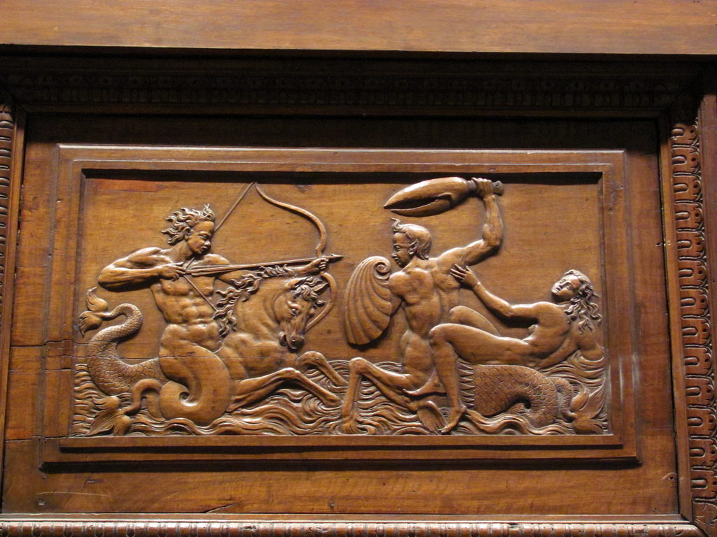 It is a merman archer riding a merhorse vs. a woman riding a mercentaur with a shell shield and giant crab claw sword.  Obviously. (Category:  Travel)